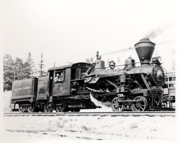 Train engine on tracks with two men looking out of the engine room. Cass Scenic R.R.; Cass, W.V.