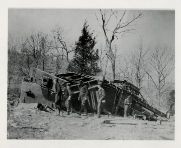 Men walking past a wrecked train.