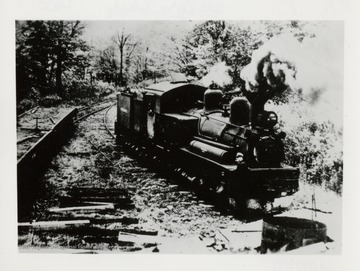 Train engine on tracks.  Lots of smoke coming from stack.  