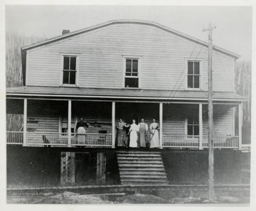 Group of women on porch, possibly a hotel or boarding house.