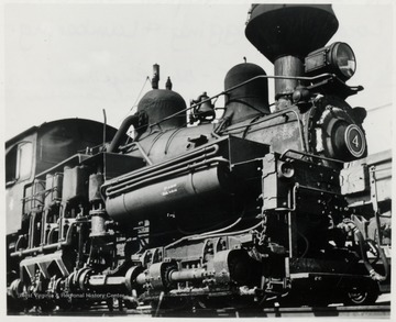 Close-up shot of a Shay train engine. Three cylinders fronting the cab of this 1880 Model Shay engine dispatches power to all twelve wheels equally.  When one wheel spins, they all spin, which is a rarity indeed.  