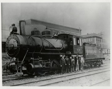 Five men standing in front of a train engine.  