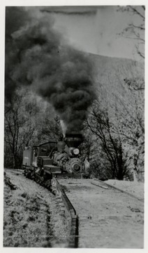 Shay train engine pushing empty carts.