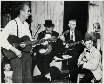 The 'Cass Symphony' plays spritely folk and logging camp tunes to the delight of a Sunday afternoon audience on the railroad station platform of the Cass Scenic Railroad.  This informal group is composed of ex-loggers.