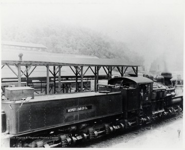 Mower Lumber Company train engine.  In doorway:  Granville Barkley.  In Window:  Guy Stanley.