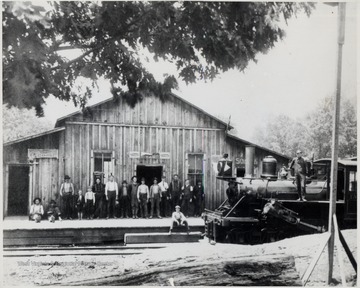 Lumber crew poses with locomotive.