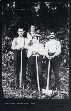 Four crew members standing with their equipment.  