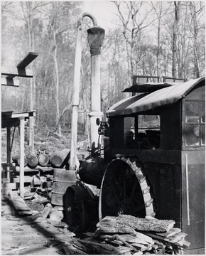 Tractor beside scraps of wood at unidentified lumber mill.