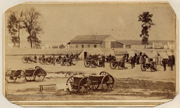 Wagons and cannons parked at an encampment. Note the laundry hanging on a caisson in the foreground.