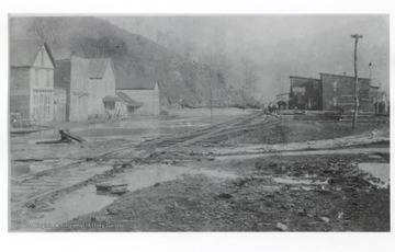 Small town with a track running through it.  Many mud puddles are present.