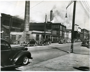 Cars parked outside of the Fostoria Glass Company Building.