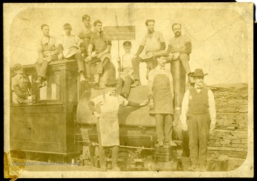 Group portrait of the Marilla Window Glass Cutters of Morgantown, W. Va. On Engine from left to right: Arthur Lewis, Hugh Fairfield, Dan McLamell, Jim Kifer, Deney Lelabey, Fred Salzman, Orcan DuBoise, Frank Dallons. Standing on Engine: Harry Davenport. Standing on platform: Arthur Swan, Bill Lewis.