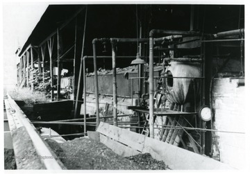 Brine Storage Tanks. The brine went from wells to storage tanks, the container in center of picture contains brine. The boiler furnishes heat, a pre-heating process for brine grainer. The brine came in from the left. Coal in foreground.