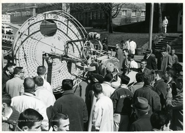 Students and others gather around the mast of the U.S.S. West Virginia, one of the ships sunk during the Japanese attack on Pearl Harbor in 1941. Identified student, bottom left corner is Thomas V. Kreitzer.