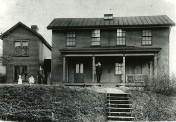 Men and children pose in front of the Fife Cottages, 1905-1916, which were used for teaching medical classes. 