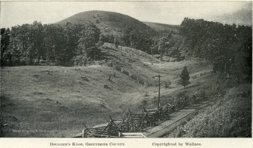 Grassy fenced in hills surround Dougher's Knob. Copyrighted by Wallace.