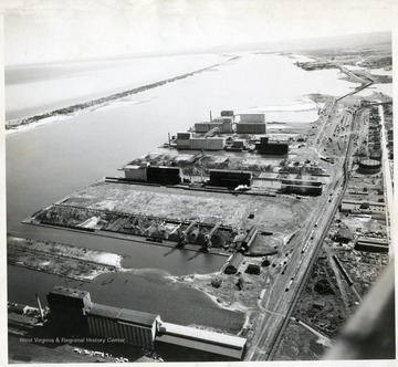 Consolidated elevators in foreground; Docks #1, Pgh Coal Co. 'abandoned'; Docks #7 'used section'; Docks #7 'abandoned section'; Consolidated Elevators; Cleveland Cliffs Coal Docks; Capitol Elevators; North Western Fuel Co. Coal Docks #4 'Consolidated Coal Co.'; Occident Elevators; Planey Elevators; Long strip of land is Minnesota and Wisconsin Points separating the harbor from Lake Superior. Photographed in fall 1942.