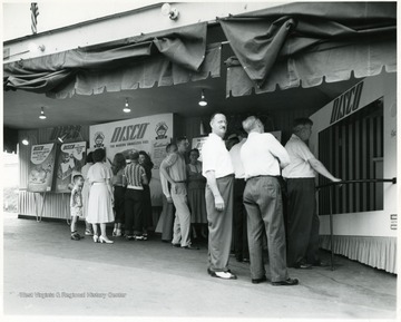 People stand around chatting and viewing the Disco Fuel exhibits.