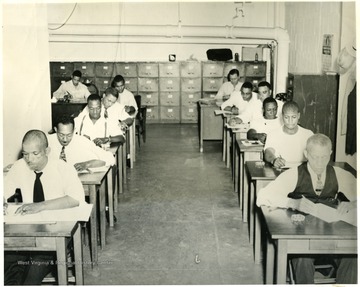 First class in 1938, Logan County, Omar, W. Va. Employees of W. Va. Coal and Coke Co., Sydnor supt. Before becoming certified, miners must pass state examination. Shown here is a group taking the examination at the state capitol, which may certify them as Mine Foremen. U.G. Carter, instructor on the left in the back. Marvin Kesler, state mine examiner on right in back.