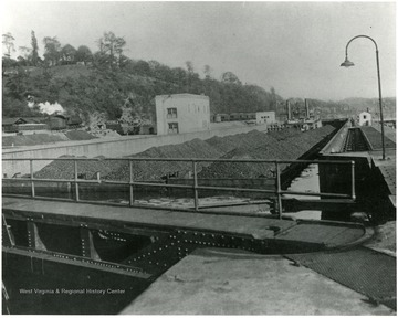 A Tow of Coal for the Jones and Laughlin Aliquippa Works locking through a dam in the Ohio River. There are 6000 tons of coal in this one movement, or enough to fill 120 freight cars of 50 tons capacity each.  The coal came down the Monongahela, which is canalized for a distance of about 70 miles above Pittsburgh and taps the richest bituminous coal district in the United States, where practically all the steel companies of the East have their coal mining operations and ship either by river or by rail. 