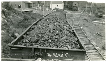 Loaded coal cars.  First car has 'No BRAKE' written on it.