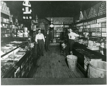 Three men in the company store at Montana Mines, W. Va. Store Manager Bartlett is first on left.