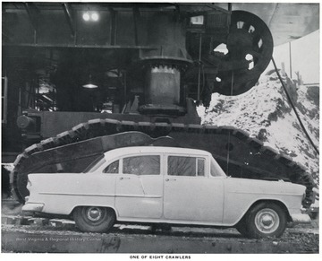 A car parked next to the Mountaineer crawler to demonstrate size.  Hanna Coal Company, Division of Pittsburgh Consolidation Coal Company.