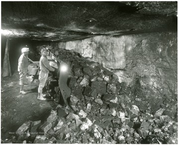 Two men working on the loading machine.