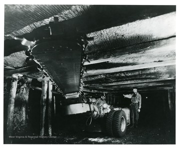 Two men working with a rubber tire mounted cutting machine.