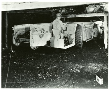 A miner operates an electric shuttle car in the mine.