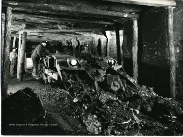 Two men operating a loading machine.