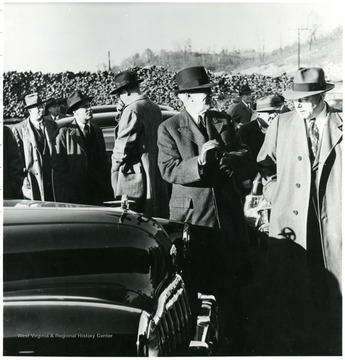 Coal officials outside by their cars.