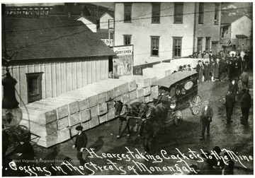 Caskets lining the street as horse-drawn hearse takes caskets to the mine.