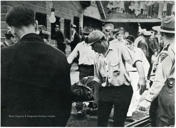 Miners carry stretchers with the victims of the mine accident at Pursglove.