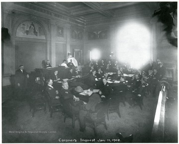 Group portrait of men who participated in the Coroner's Inquest after the Monongah Mine Disaster.  1. to 6. Coroner's Jury, 7. R.S. Larue, 8. J.W. Paul, 9. Chas. Powell, 10. J.C. Gaskill, 11. S.C. Lowe, Prosecuting Attorney, 12. Interpreter, 13. J.G. Smyth, 14. G.M. Alexander, 15. E.B. Moore, 16., C.W. Watson, 17. L.L. Malone, 18. Frank Haas, 19. H.V. Hesse, 20. J.W. Stevens, 21. C.E. Scott, 22. A.J. Ruckman, 23. W.H. Bailey, 24. E.S. Amos (coroner), 25. Stenographer, 26. D. Victor, 27. J.H. Wheelwright. 