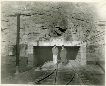 Two men stand in front the New Cinderella mine entrance.