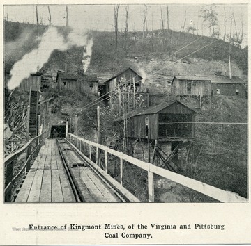 A coal mine entrance is surrounded by various buildings of the mine.