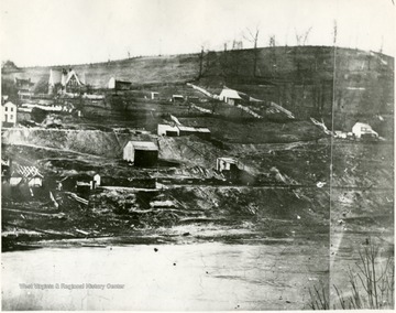 'American Coal Company formed in 1852, James Otis Watson, President. First bituminous coal mine to ship commercial coal west of the Alleghany Mountains. Gabled home in the background was the Ogden home.'