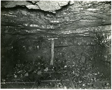 Shows timber roof-support and mine railway track.