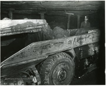 Minre watches as coal pours into the shuttle car.