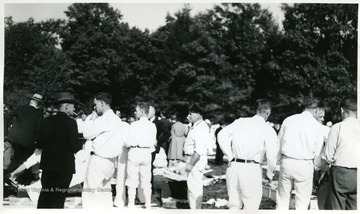 Men in white uniforms watch mine safety exercises.