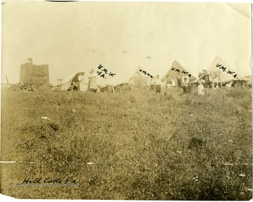 Children and a mother with a baby stand outside of U.M.W.A. tents in a field at Hill Coke, PA.