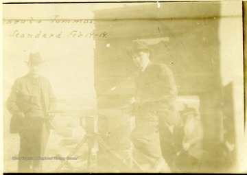 Man holding a tripod mounted gun. 