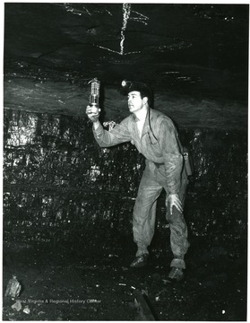 Miner tests for gas in mine.