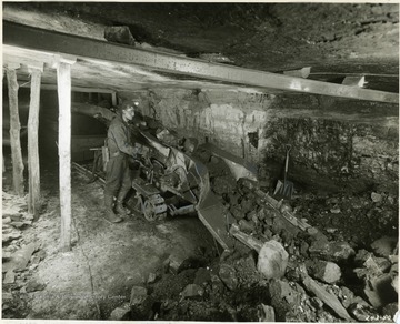 Miner operating a Joy Loading Machine. '180 tons a day.' 