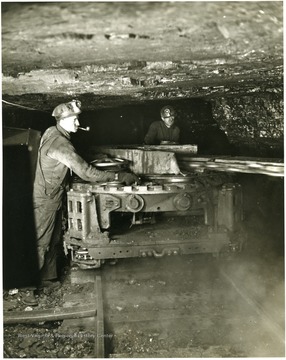 Two miners work with a cutting machine at Mine 206, Kentucky. 'This material is the property of the Consolidation Coal Co. and must be returned promptly to: Advertising Department, Consolidation Coal Company, 30 Rockefeller Plaza, New York, N.Y.