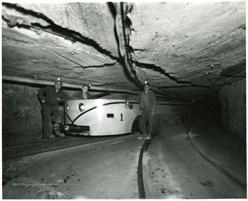 Miners stand next to a large locomotive at Jamison No. 9.