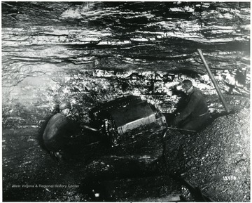 Two miners work with a mining machine. 'Compliments of Jeffrey Manufacturing Co.' John Williams, Coal Life Project.