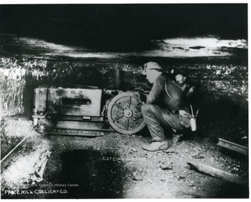 A miner is operating a cutting machine at the Price Hill Colliery Co. mine