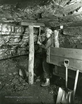 Man properly carrying prop and setting safety timber.